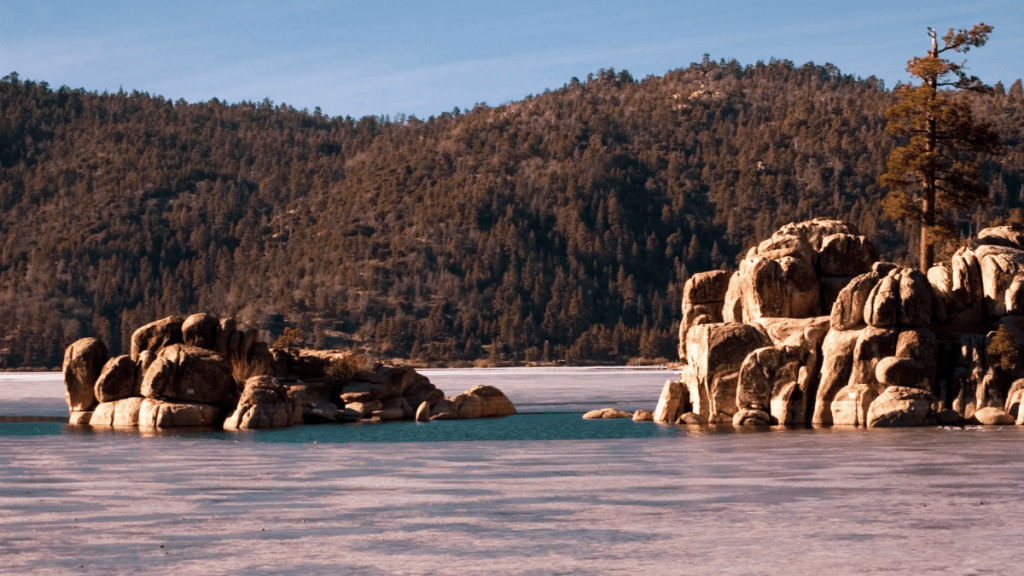 Boulder Bay Park overlooking Big Bear Lake. There are mountains in the background covered in trees.